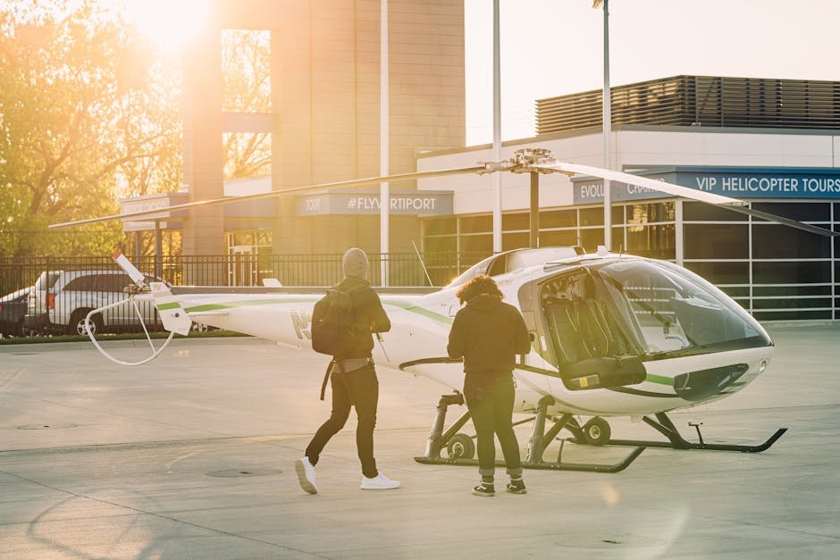 Two people preparing a helicopter for flight at a helipad, illustrating the start of helicopter pilot training.
