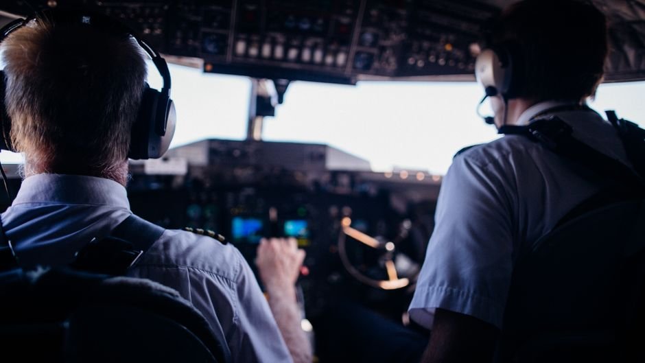 Pilot wearing a headset in the cockpit during a training flight.