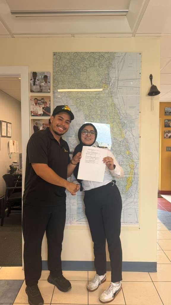 Pelican student Jasra holding her temporary certificate after passing the Commercial checkride