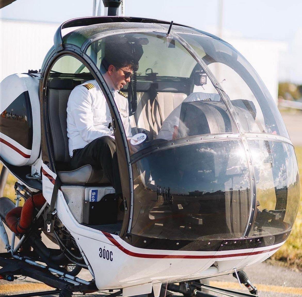 Pelican Flight School graduate preparing for takeoff inside a helicopter cockpit.